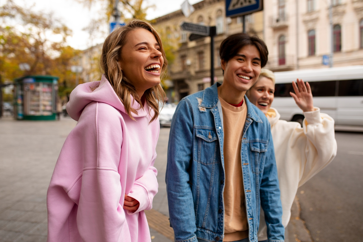 Group of friends laughing together while walking outside in the city